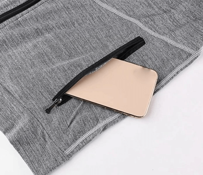 Close-up of gray men's hooded sweatshirt with zipper pocket and smartphone inside, showcasing anti-pilling fabric.